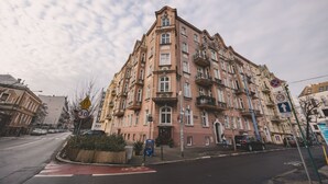A multi-story building with a classic architectural style, featuring a central entrance and multiple balconies. - Botella Kr Lewskie Studio w Sercu Poznania (Poznań)