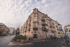 A multi-story building with a classic architectural style, featuring a central entrance and multiple balconies. - Botella Kr Lewskie Studio w Sercu Poznania (Poznań)