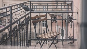 A balcony with a wooden bench and a metal railing. - Botella Kr Lewskie Studio w Sercu Poznania (Poznań)
