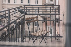 A balcony with a wooden bench and a metal railing. - Botella Kr Lewskie Studio w Sercu Poznania (Poznań)