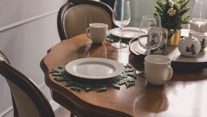 A dining table set with plates, cutlery, and glassware, with a decorative pine tree centerpiece. - Botella Kr Lewskie Studio w Sercu Poznania (Poznań)
