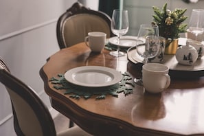 A dining table set with plates, cutlery, and glassware, with a decorative pine tree centerpiece. - Botella Kr Lewskie Studio w Sercu Poznania (Poznań)