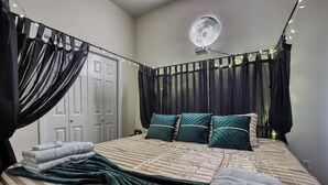 A neatly made bed with a striped bedspread, two pillows, and a blanket. - Projector - 5 mins to DT - 4 King Beds - Massage Chair (Savannah)