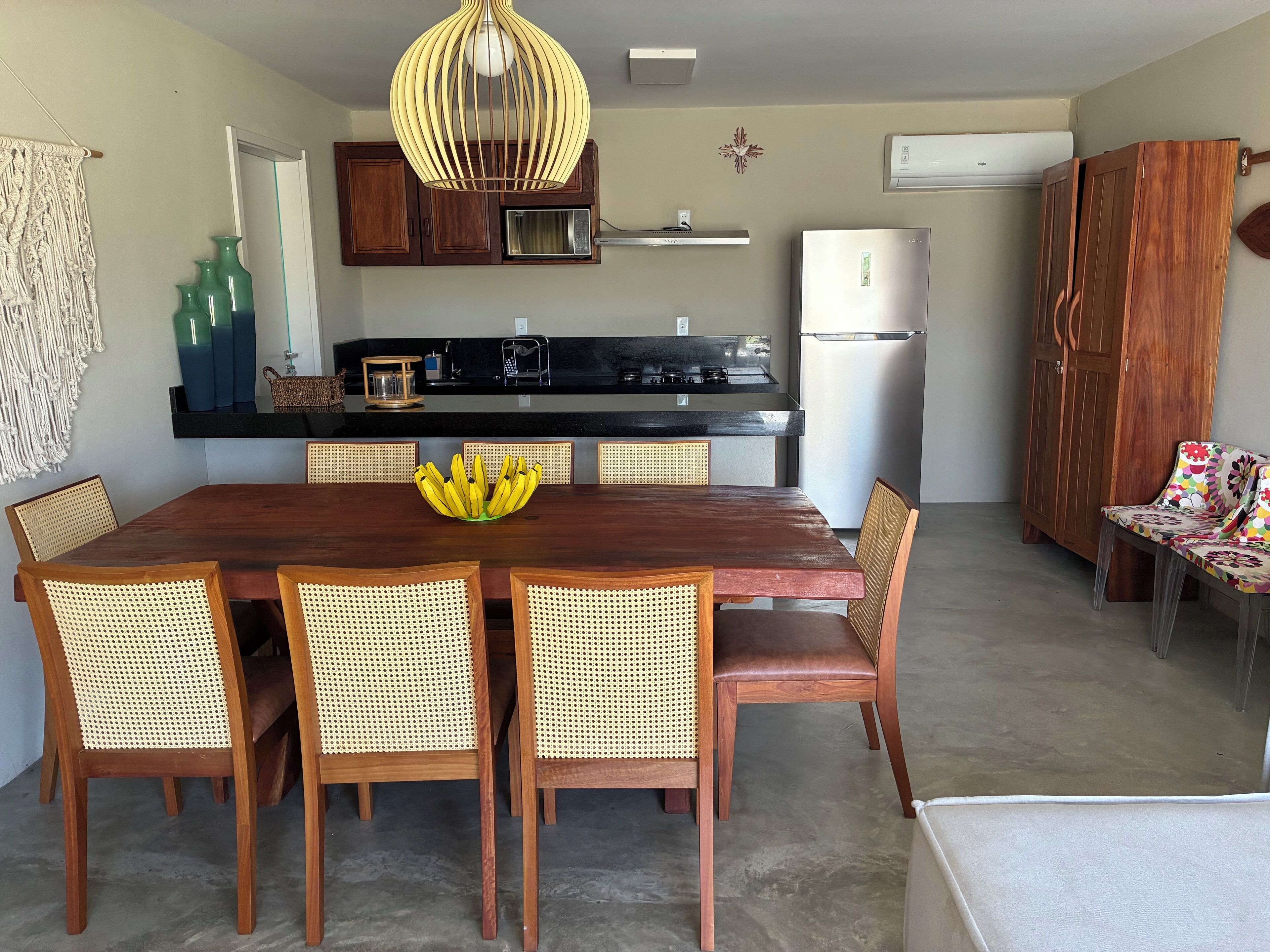 A modern kitchen with wooden cabinets, a black countertop, and a white refrigerator.