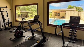 A gym with treadmills, a stationary bike, and a weight bench. - Casa Milagres Reserva do toque (São Miguel dos Milagres)
