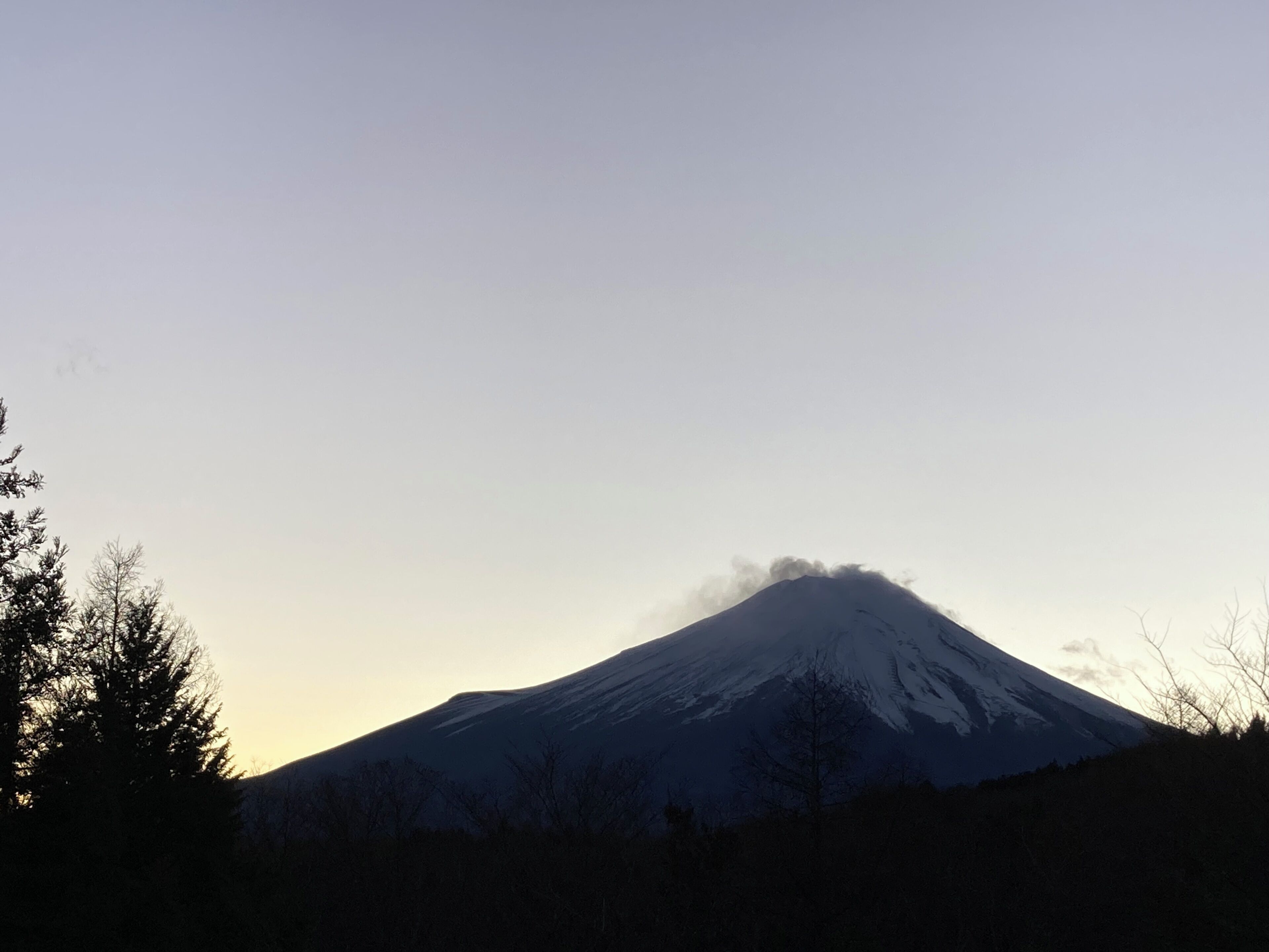 A mountain with a snow-covered peak and a clear sky.