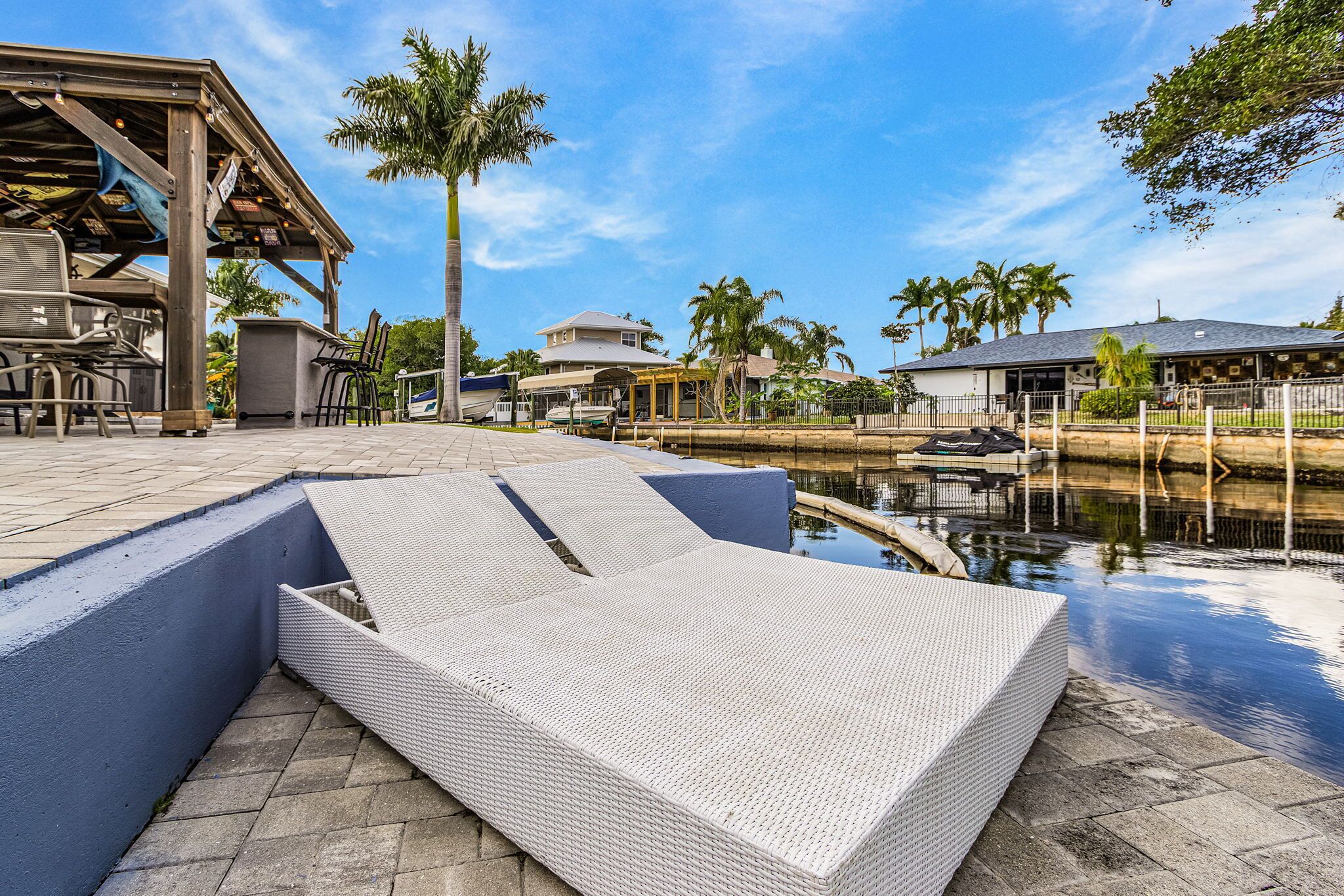 Area piscina con zona relax coperta, elemento d'acqua e vista sul paesaggio circostante.