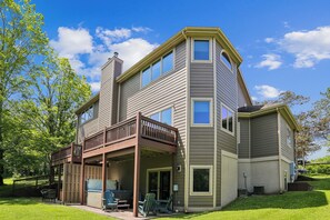 A two-story house with a deck, a covered patio, and a garage. - A Wisp-Er Away: 5BR retreat at Wisp,hot tub & fire pit, Ski, Golf (McHenry)
