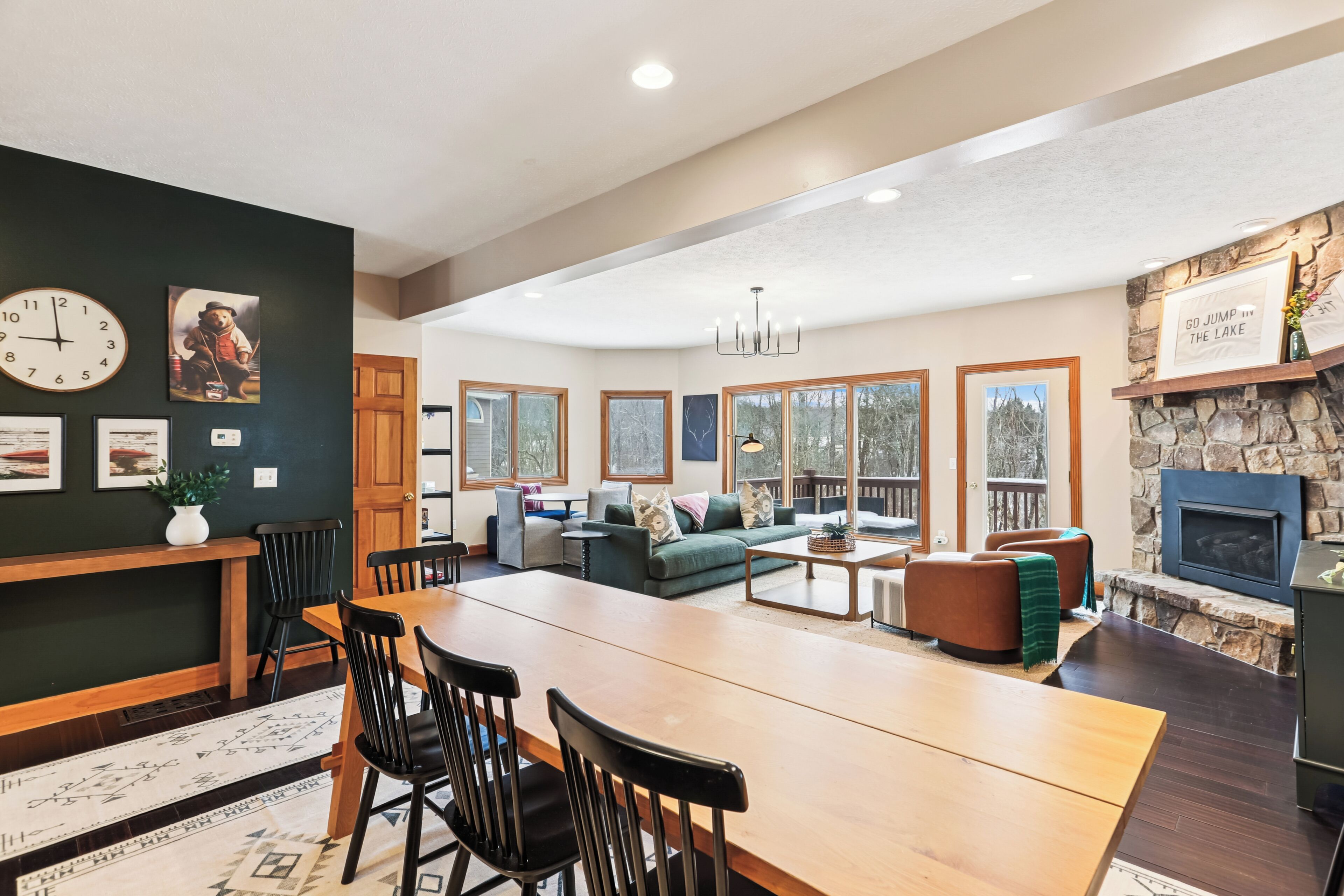 A spacious living area with a dining table, chairs, a sofa, and a fireplace.