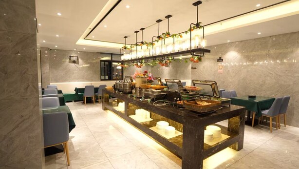A modern buffet setup with a marble countertop, various food stations, and seating areas. - GreenTree Inn Fuzhou Sanfang Qixiang  (Fuzhou)