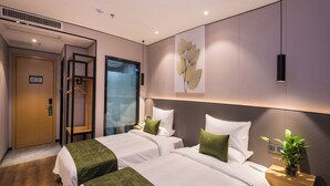 A hotel room with two beds, a glass partition, a wooden door, and a wall-mounted plant. - GreenTree Inn Fuzhou Sanfang Qixiang  (Fuzhou)