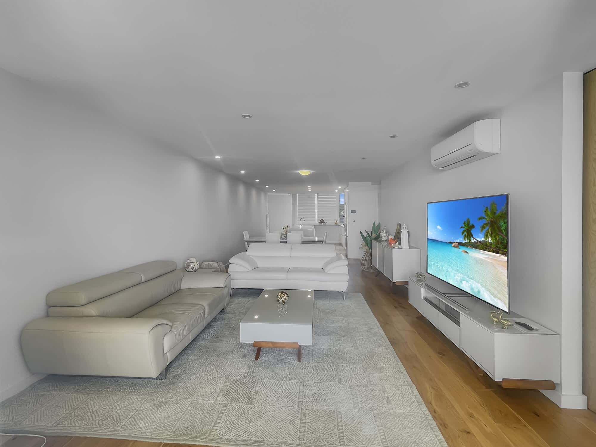 A modern living room with a sofa, coffee table, and TV.
