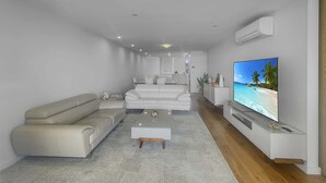 Een moderne woonkamer met een bank, salontafel en televisie.