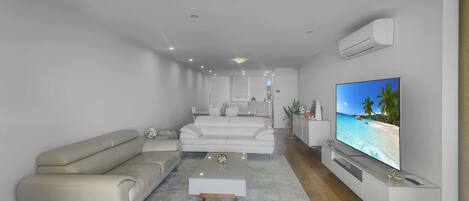 A modern living room with a sofa, coffee table, and TV.