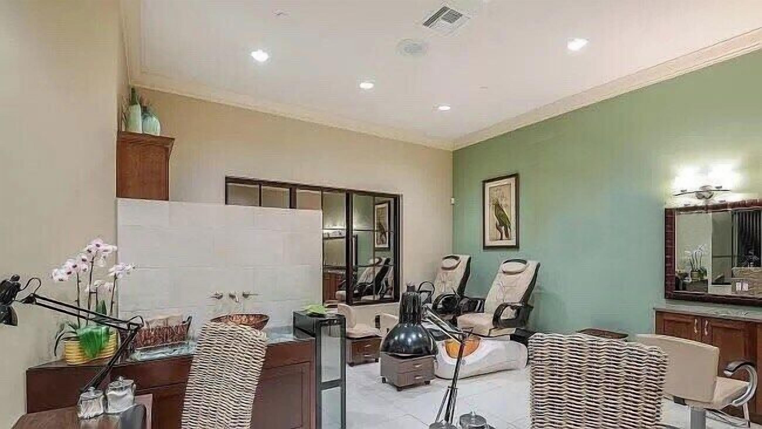 A spacious living area with a large window, a dining table, and several chairs.