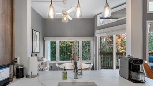 A modern kitchen with a marble countertop, a built-in sink, and a coffee maker. - Bridges Cozy Hideaway at Sugarbush (Warren)