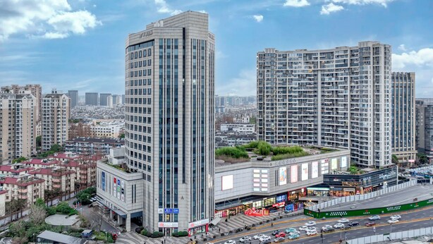 Ein Hochhaus mit modernem Design, gekennzeichnet durch einen markanten Eckbau und einen Dachgarten.