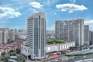 Een hoog gebouw met een modern ontwerp, met een opvallende hoekstructuur en een dakbostuin.