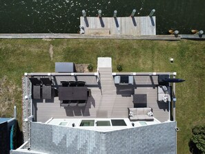 En tagterrasse med udendørs møbler, en lille pool og udsigt til vandet.