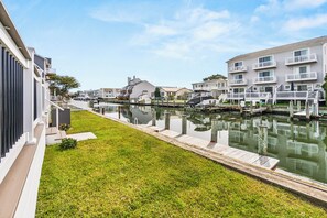 Zona residencial com canal, casas com varandas e gramado.