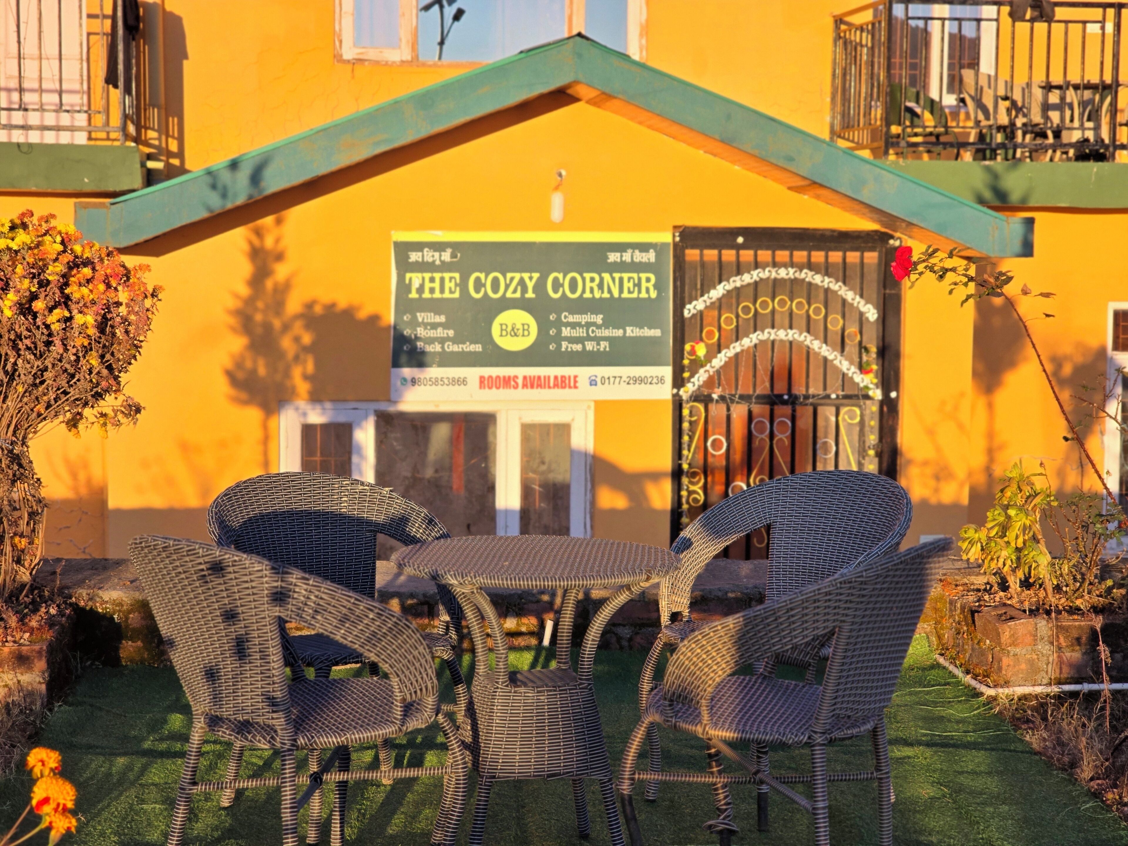 Naamplaatje voor 'The Cozy Corner' met voorzieningen zoals villa's, een kampvuur, een achtertuin en gratis Wi-Fi.