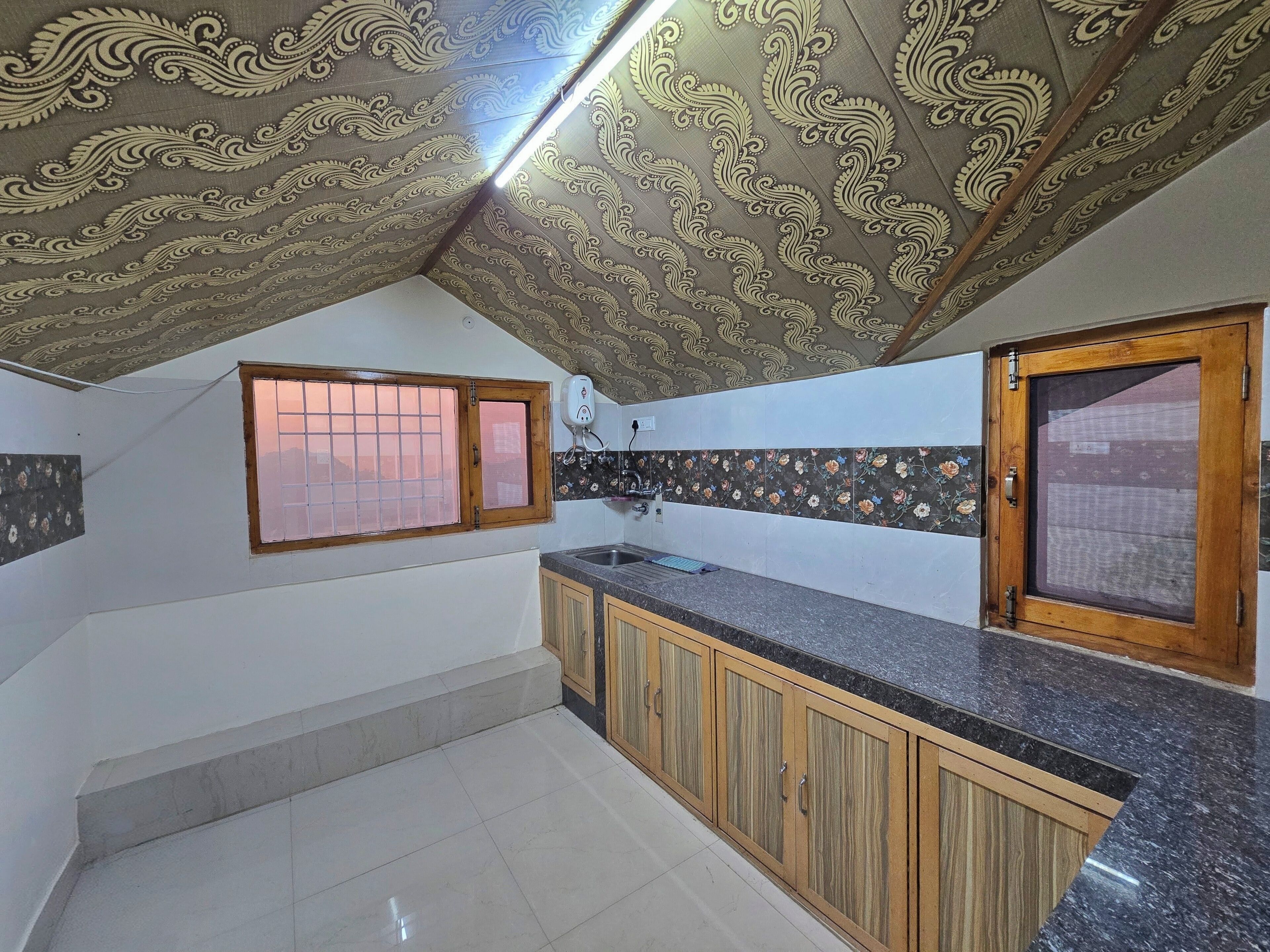 A kitchen with wooden cabinets, a granite countertop, and a decorative ceiling.