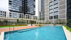 Une piscine moderne, bordée de carreaux, entourée d’une terrasse en briques.