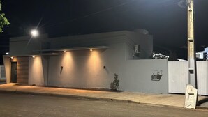 Un edificio moderno con techo plano, una sola entrada y un pequeño jardín.