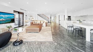 Un espacio habitable moderno con un sofá, una mesa de centro y un televisor que muestra una vista panorámica.