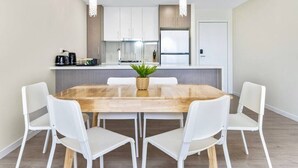 A modern kitchen with white cabinets, a central island, and pendant lighting. - Botany 2Br Apt near Airport/Bay/City with 2Parking (Botany)