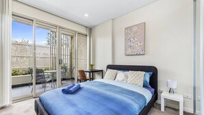A bedroom with a large bed, a desk, and a chair. - Botany 2Br Apt near Airport/Bay/City with 2Parking (Botany)
