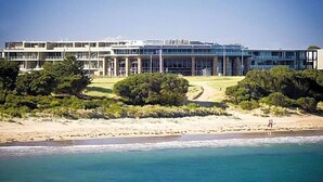 Um hotel à beira-mar com design arquitetônico moderno, com vários andares e grandes janelas.