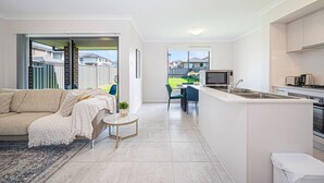 Un appartement moderne comprenant un salon, une cuisine et un balcon avec vue.