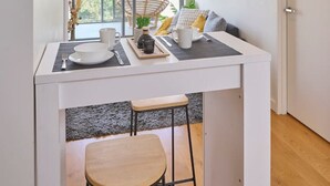 Une cuisine moderne avec un coin repas, de grandes fenêtres et une vue sur la ville.