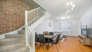 Ein moderner Wohnraum mit Treppe, Essbereich und einer Sitzecke mit Blick auf einen Fluss.