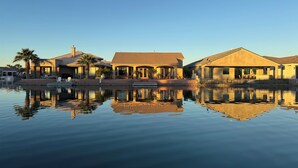 Una propiedad frente al agua con varios edificios, una piscina y cielo despejado.