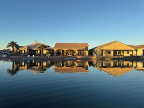 Ein Anwesen am Wasser mit mehreren Gebäuden, einem Schwimmbad und blauem Himmel.