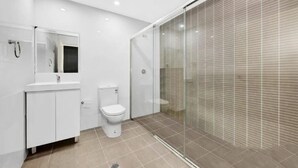 A modern bathroom with a toilet, sink, and glass shower enclosure. - 2BR APT near Train Station/4ppl/Couple/Business (Canterbury)