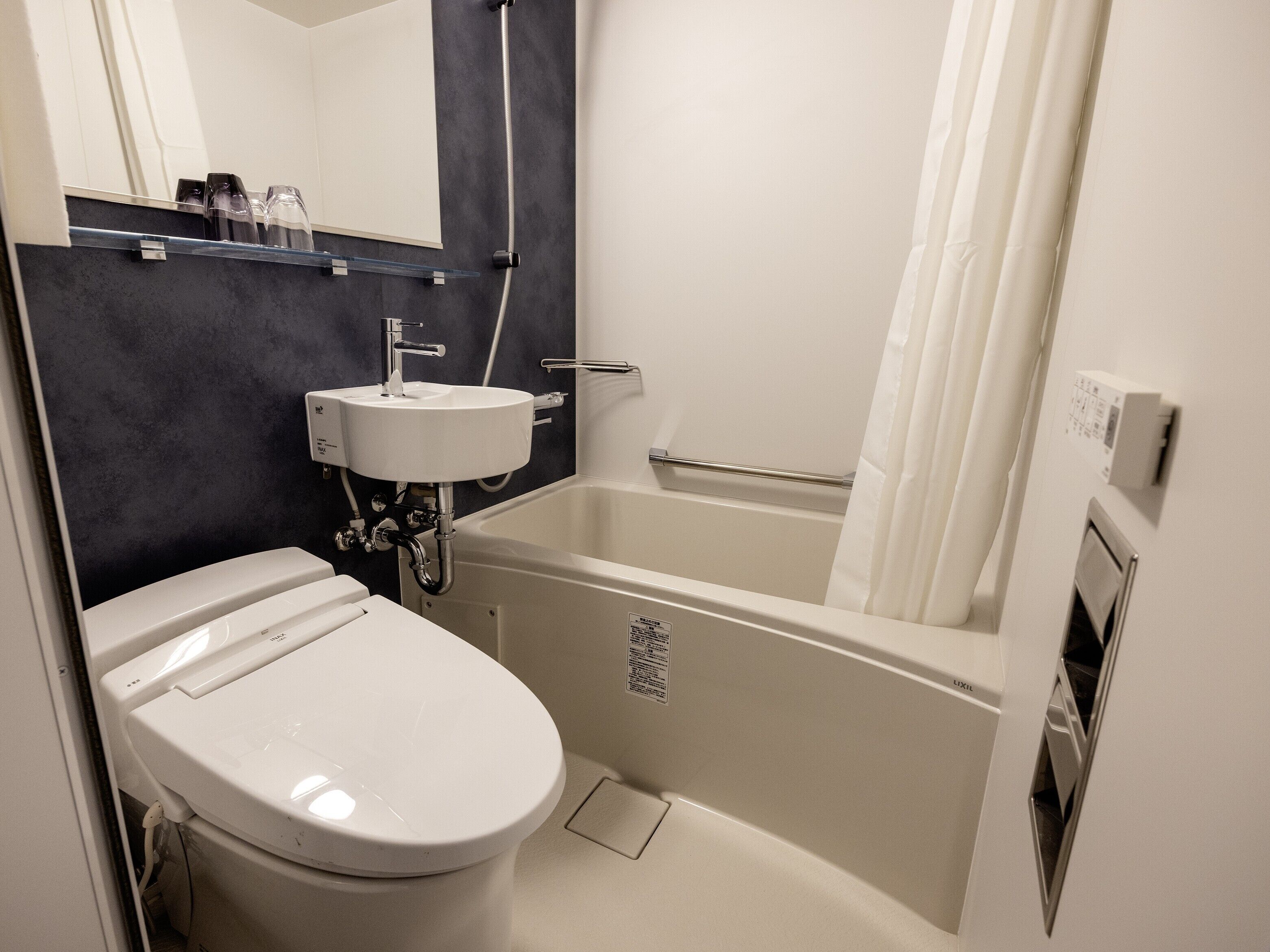 A bathroom with a toilet, sink, and bathtub.