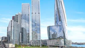 Een moderne stedelijke skyline met wolkenkrabbers, waaronder een opvallend gebogen torens.