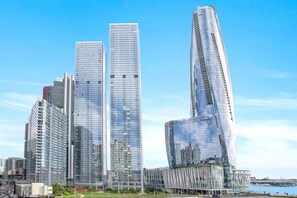 A modern urban skyline with high-rise buildings, including a distinctive twisting skyscraper. - Waterfront CBD luxury 3Br  with Parking for 8 ppl (Barangaroo)