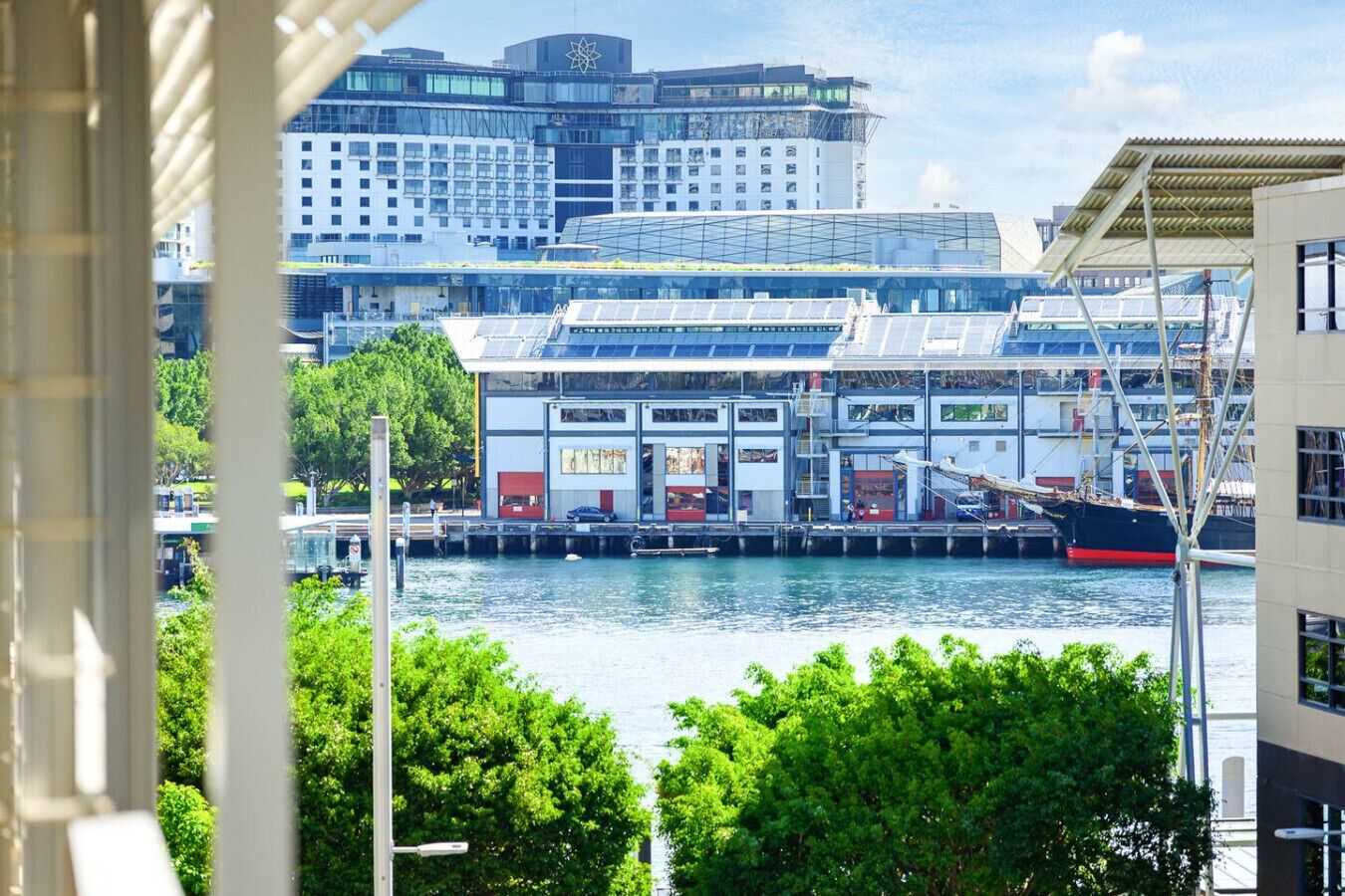 A waterfront building with a modern architectural design, featuring large windows and a flat roof.