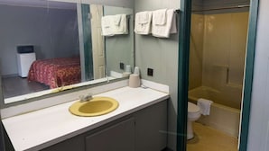 A bathroom with a sink, mirror, and toilet.