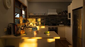 Een moderne keuken met een centraal eiland, een inbouwoven en een roestvrijstalen koelkast.