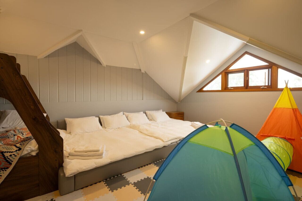 Quarto com cama, janela e uma tenda.