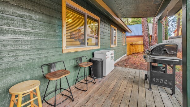 A wooden deck with a grill and two stools. - Evergreen Escape- Great location near downtown w/trailer parking and fully fenced yard (McCall)