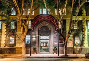 A building with a prominent arched entrance, a staircase leading to the entrance, and trees framing the scene. - Sydney CBD 1Br with Spa/Pool/Sauna/Gym by ICC (Pyrmont)