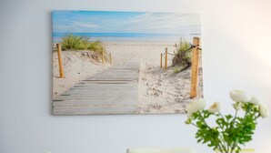 A beach scene with a wooden pathway leading to the shore, framed on a wall. - Collaroy 3Br with pool / Breath and Relax (Collaroy)