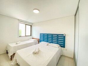 A hotel room with two beds, a window, and a ceiling light. - Carneiros Beach Resort by CTA (Tamandaré)