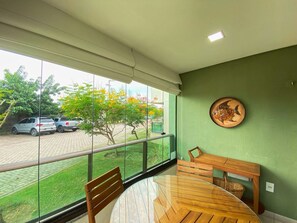 A room with a glass wall, a wooden table, and a bench. - Carneiros Beach Resort by CTA (Tamandaré)